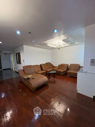 Spacious living room with elegant leather sofas and wooden flooring, perfect for relaxation and entertainment.