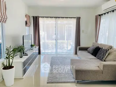 Modern living room with stylish decor, large windows, and comfortable seating in a bright, airy space.