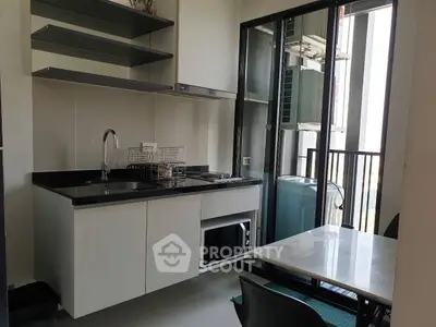 Modern kitchen with sleek cabinets, open layout, and balcony access for a bright, airy feel.