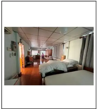 Spacious bedroom with wooden flooring and natural light