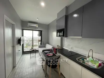 Modern apartment with open kitchen and living area, featuring a balcony with city view.