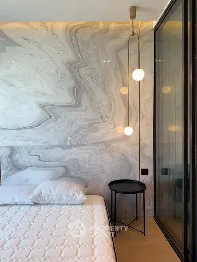 Luxurious bedroom with marble accent wall and modern lighting