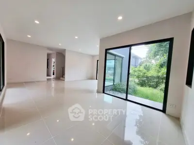 Spacious modern living room with large windows and garden view, perfect for family gatherings.