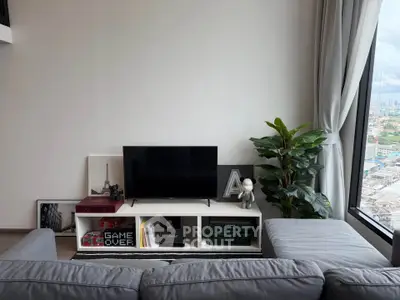 Modern living room with sleek TV setup and panoramic city view, perfect for urban living.