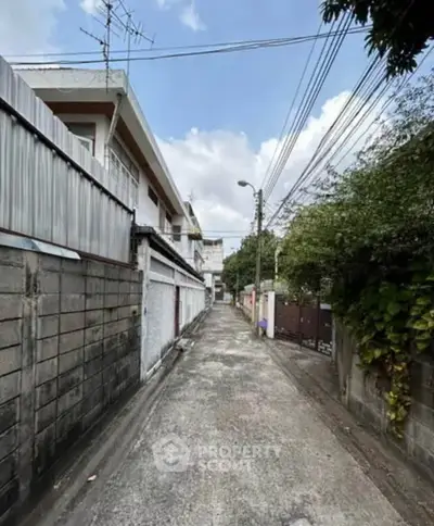 Charming alleyway view with urban residential buildings and lush greenery, perfect for serene city living.