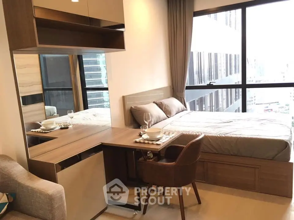 Modern bedroom with city view, featuring a cozy bed and stylish furniture.