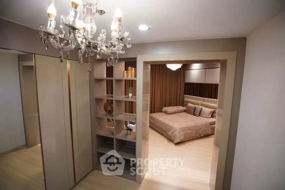 Luxurious bedroom with elegant chandelier and modern shelving unit, perfect for stylish living.