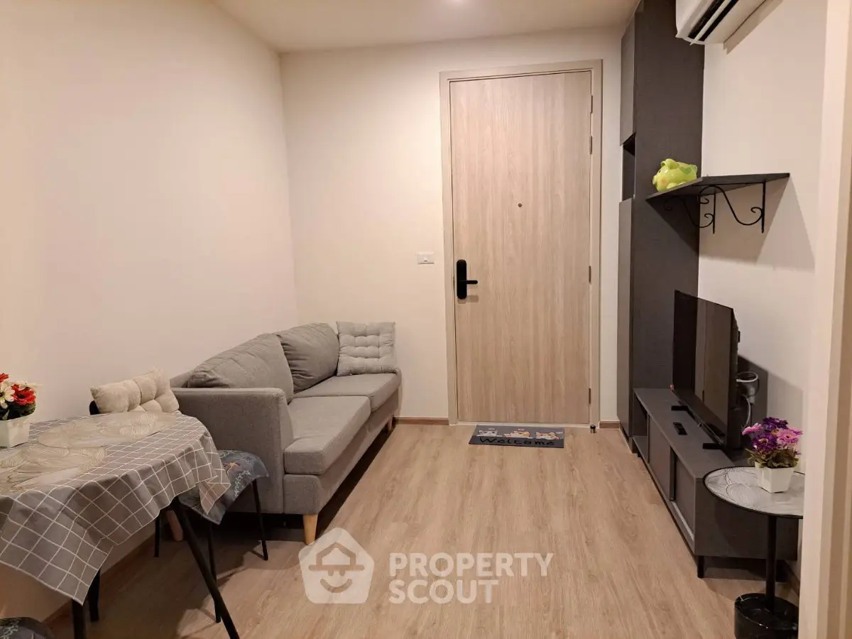 Cozy living room with modern decor, featuring a comfortable sofa, TV, and stylish wooden flooring.