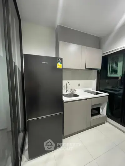 Modern kitchen with sleek cabinetry and stainless steel appliances in a compact layout.