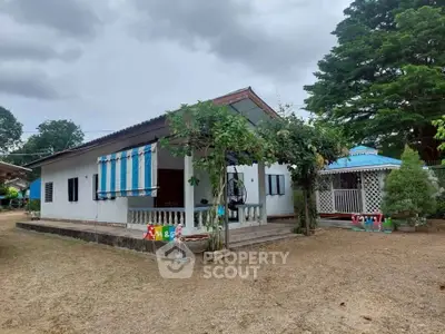Charming single-story home with a spacious yard and covered porch, perfect for family living.