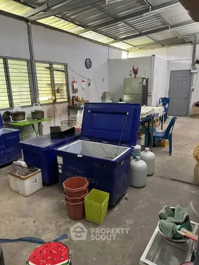 Spacious industrial-style storage area with large containers and metal roof, ideal for business operations.