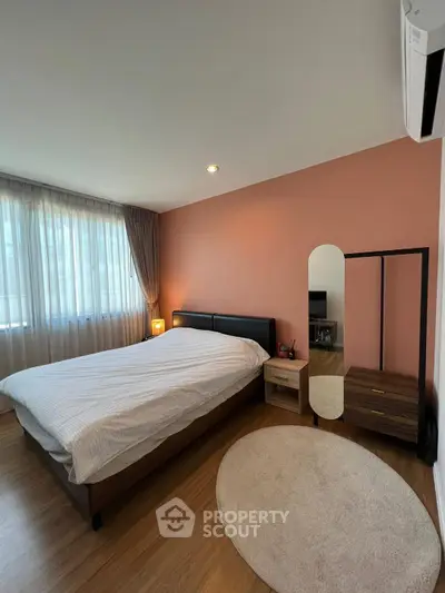 Cozy bedroom with modern decor, featuring a large bed, stylish mirror, and soft lighting.