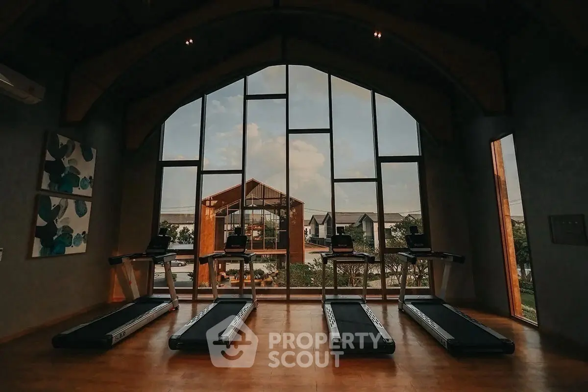 Luxurious gym with panoramic window view in modern real estate property