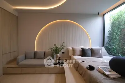 Luxurious modern bedroom with stylish lighting and cozy seating area
