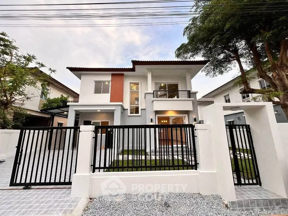 Stunning modern two-story house with gated entrance and spacious driveway.