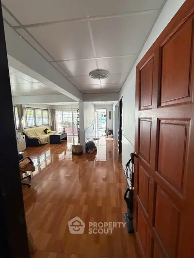 Spacious living area with wooden flooring and ample natural light.