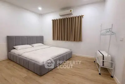 Spacious bedroom with modern decor and cozy ambiance, featuring a plush bed and minimalist design.