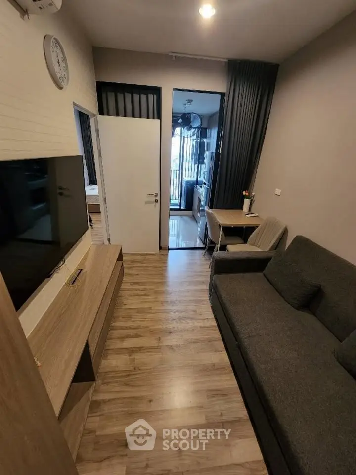 Modern living room with sleek wooden flooring and stylish furniture in a cozy apartment.