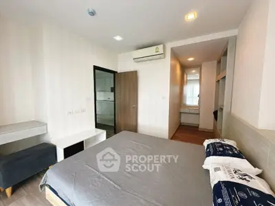 Modern bedroom with stylish decor and ample natural light, featuring a cozy bed and sleek air conditioning unit.