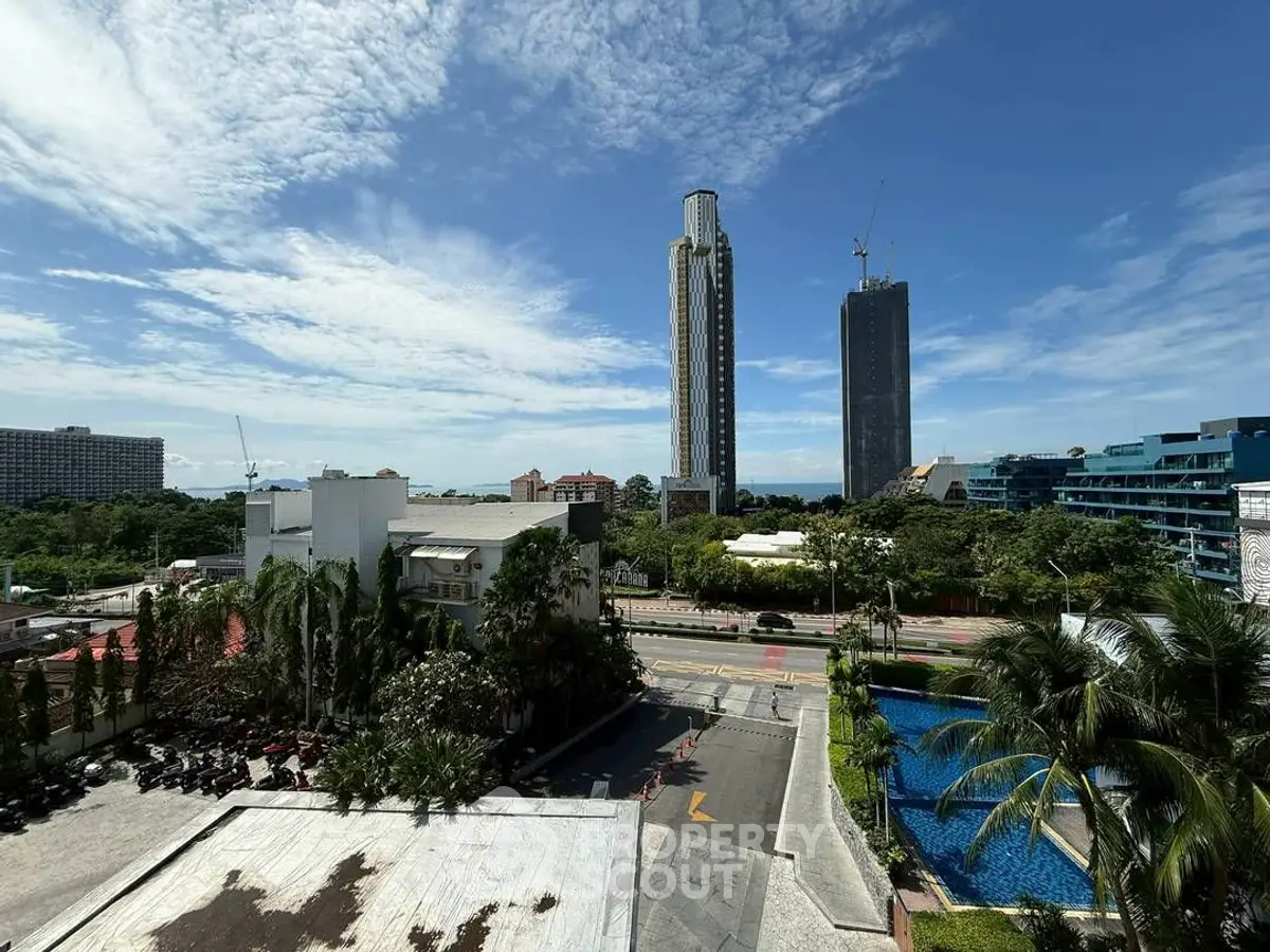 Stunning cityscape view with modern high-rise buildings and lush greenery under a clear blue sky.
