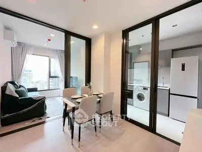 Modern apartment interior with open living and dining area, featuring large windows and a sleek kitchen.