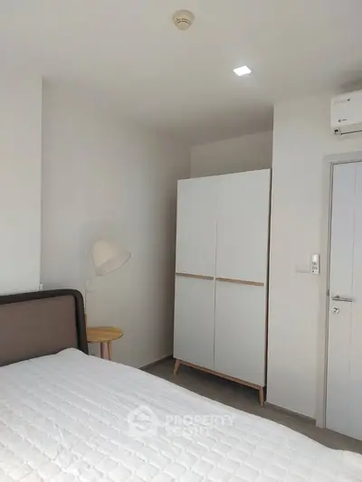 Modern bedroom with minimalist design featuring a sleek wardrobe and cozy bed.