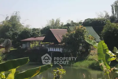 Charming rural property with lush greenery and serene pond view, perfect for nature lovers seeking tranquility.