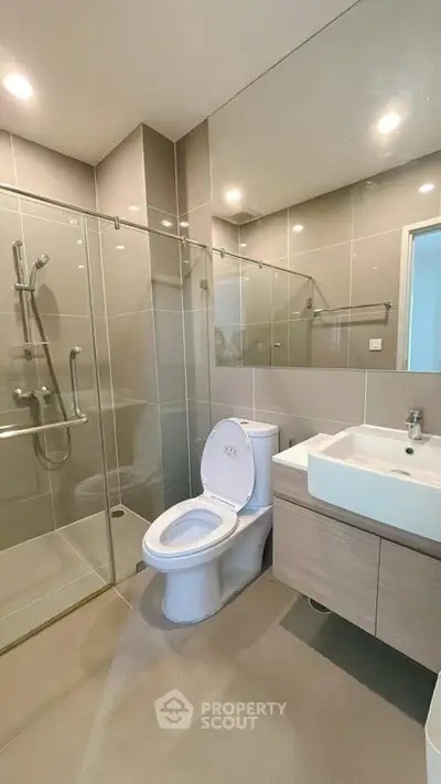 Modern bathroom with glass shower and sleek fixtures in a contemporary apartment.