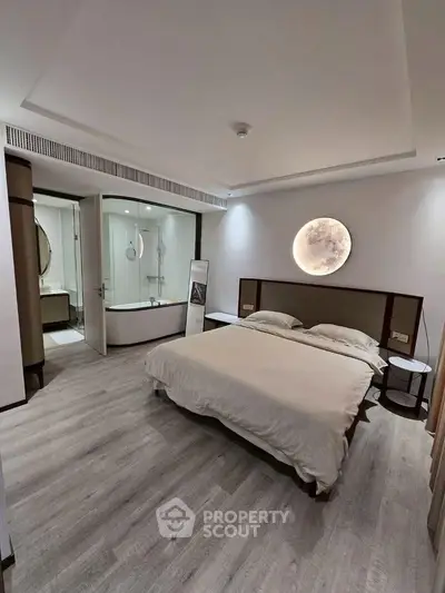 Luxurious bedroom with modern design and ensuite bathroom featuring elegant lighting and wood flooring.