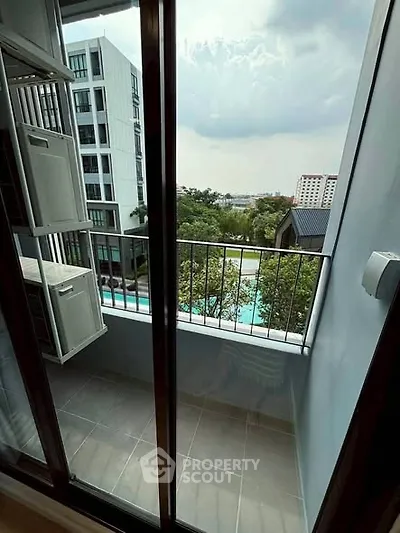 Charming balcony with pool view in modern apartment complex.