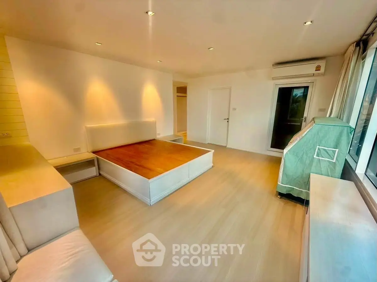 Spacious bedroom with modern design and large windows offering natural light.