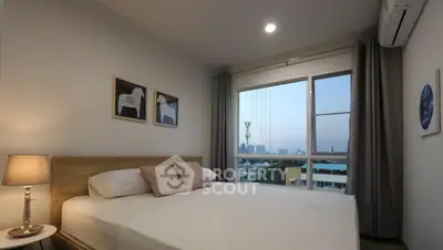 Cozy bedroom with city view, featuring a comfortable bed and modern decor.