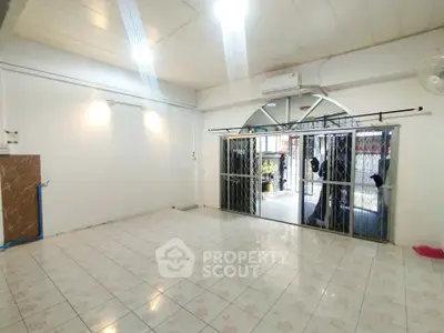 Spacious tiled room with sliding glass doors and air conditioning, ideal for versatile living space.