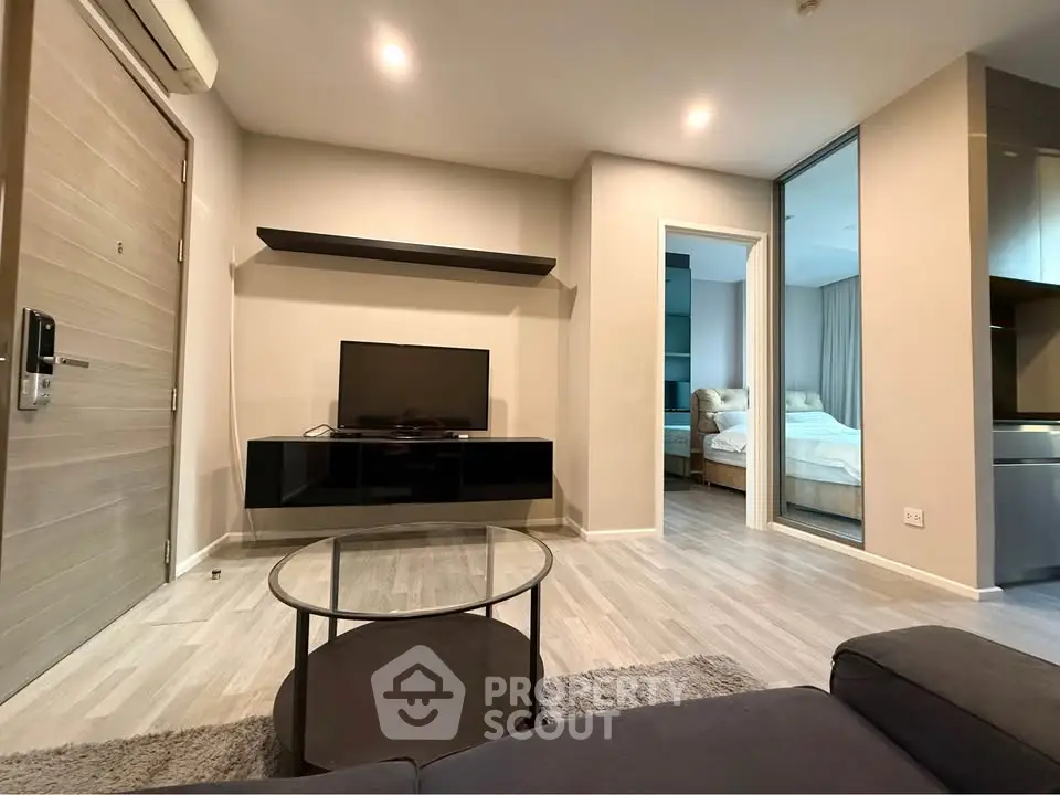 Modern living room with sleek furniture and open view into a cozy bedroom, showcasing contemporary design.