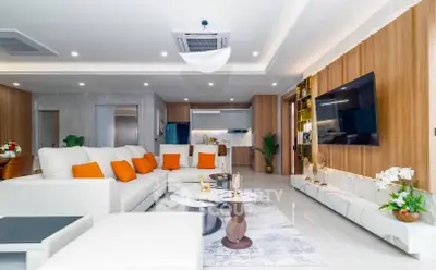 Luxurious modern living room with elegant decor and open kitchen layout, featuring plush seating and stylish accents.