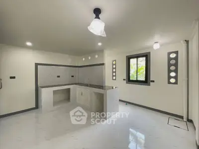 Modern kitchen with sleek countertops and ample natural light, perfect for culinary enthusiasts.