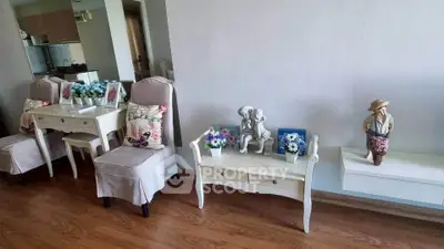 Charming living room with elegant decor and wooden flooring, featuring stylish chairs and decorative accents.