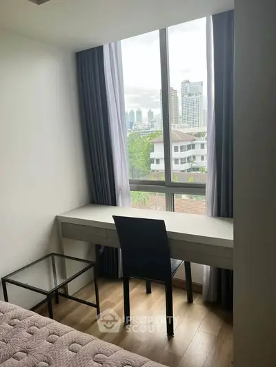 Modern study room with city view, featuring sleek desk and chair, ideal for work-from-home setup.