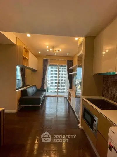 Modern kitchen with sleek appliances and open layout leading to a balcony with city view.