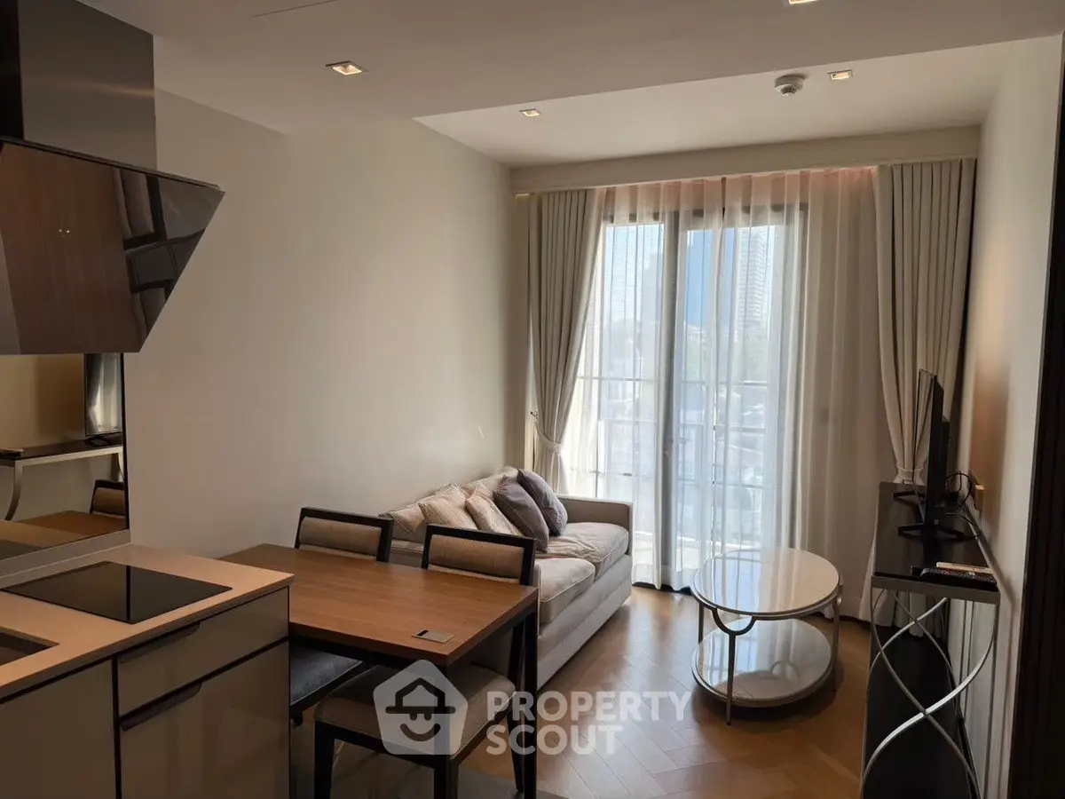 Modern living room with open kitchen and large windows in a stylish apartment.