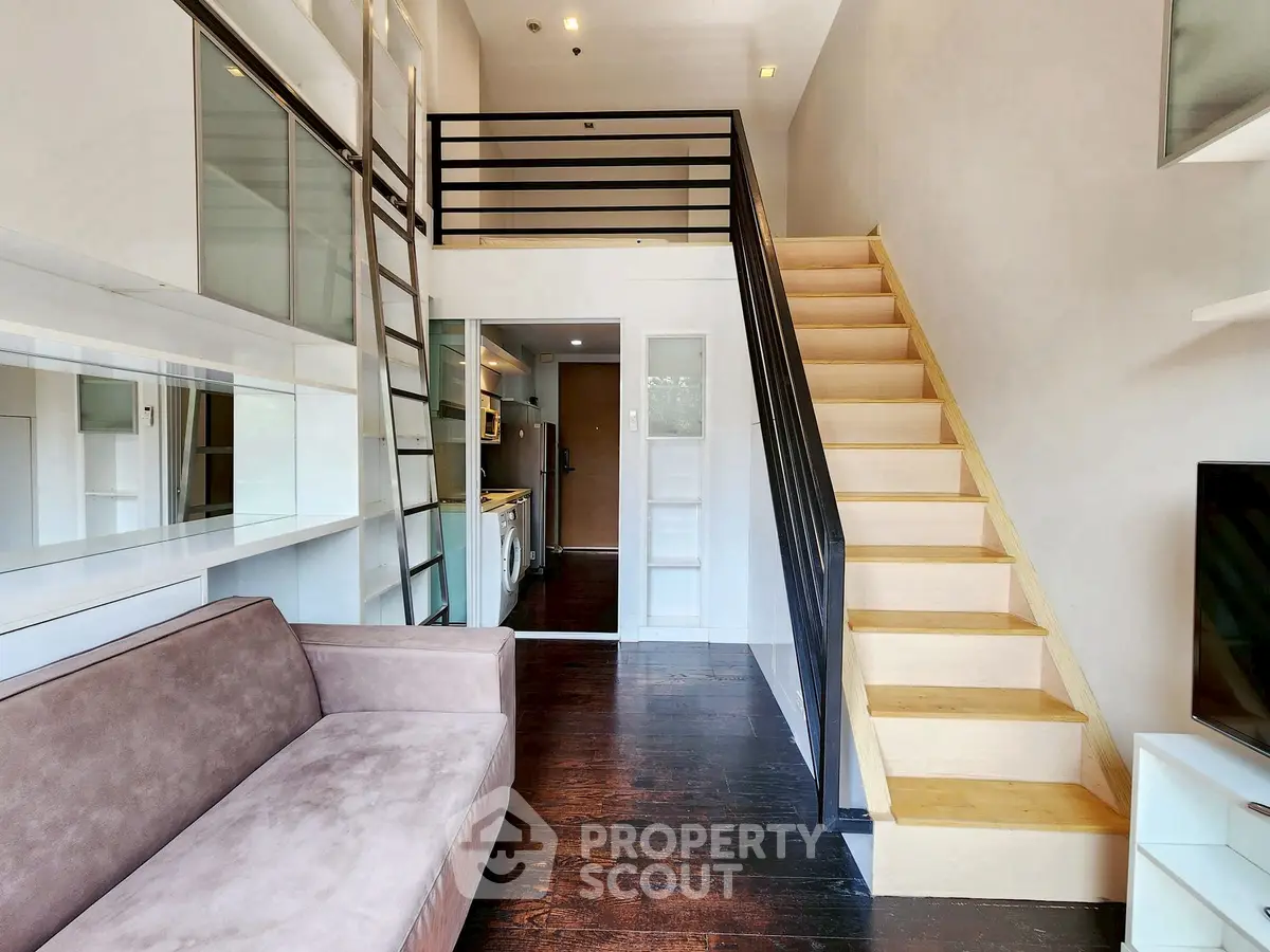 Modern loft apartment with mezzanine, sleek kitchen, and cozy living area.