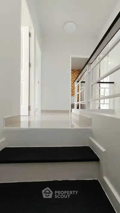 Bright and modern hallway with sleek railing and glossy floors