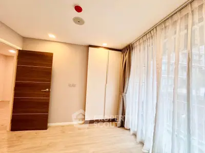 Bright bedroom with large windows and modern wooden door