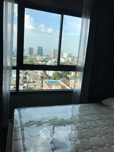 High-rise bedroom with stunning city view through large window