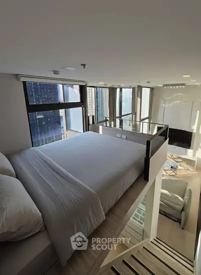 Modern loft bedroom with panoramic city views and stylish interior design.