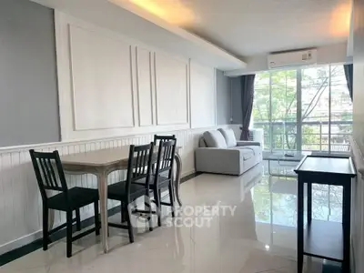 Spacious living room with modern decor and large windows offering natural light and scenic views.