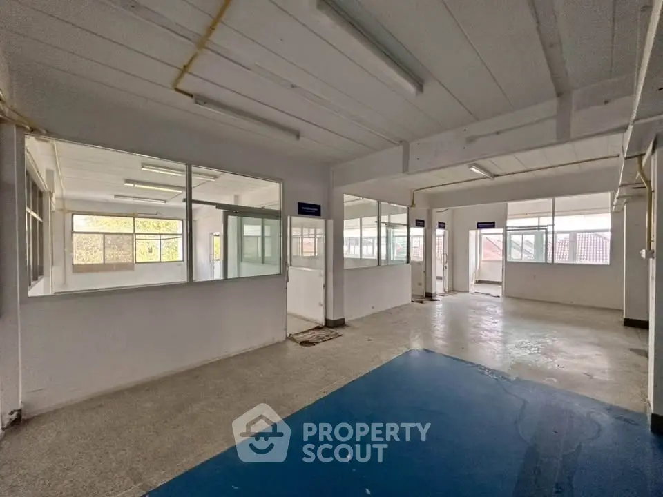 Spacious commercial interior with large windows and open layout, ideal for office or retail space.