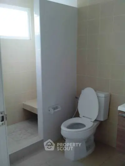 Modern bathroom with tiled walls and a sleek toilet design.