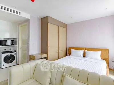 Modern bedroom with washing machine and cozy sofa in stylish apartment.