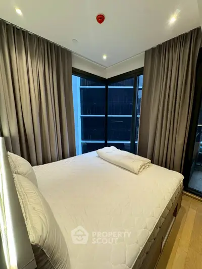 Modern bedroom with large windows and elegant curtains in a high-rise building.